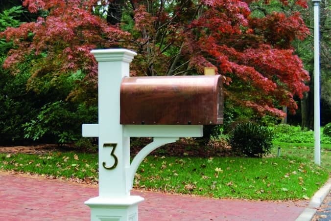 a latern post with a house address sign